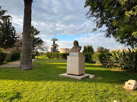 Famagusta, Cyprus - February 1, 2022: A solitary statue standing amidst neatly trimmed green grass, a symbol of tranquillity.