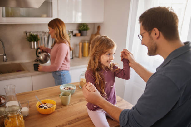 istock Happy family having breakfast at table in kitchen 2147681150