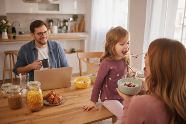 istock Happy family having breakfast at table in kitchen 2147681370