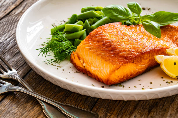 istock Seared salmon steak with boiled green bean on wooden table 2147681441