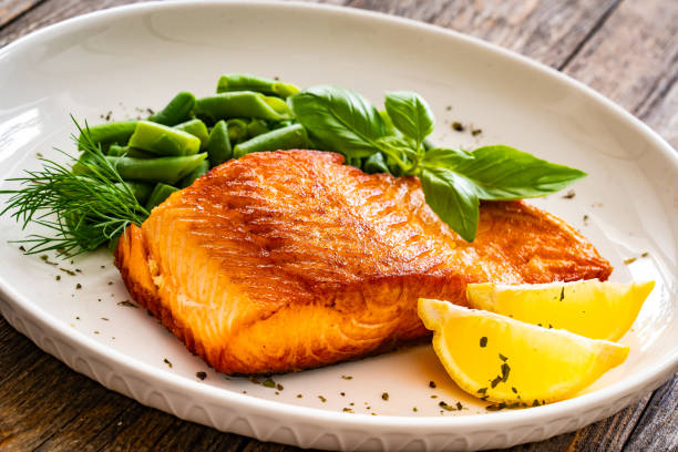 istock Seared salmon steak with boiled green bean on wooden table 2147681460