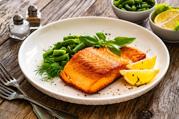 istock Seared salmon steak with boiled green bean on wooden table 2147681480