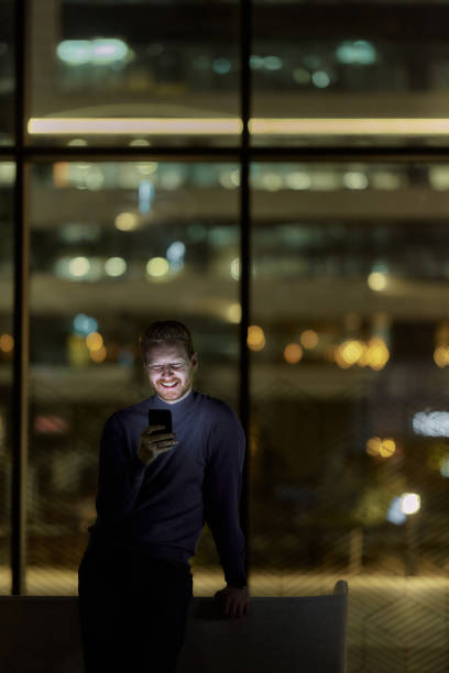 istock Happy man reading a text message on smart phone in the dark. 2147681974
