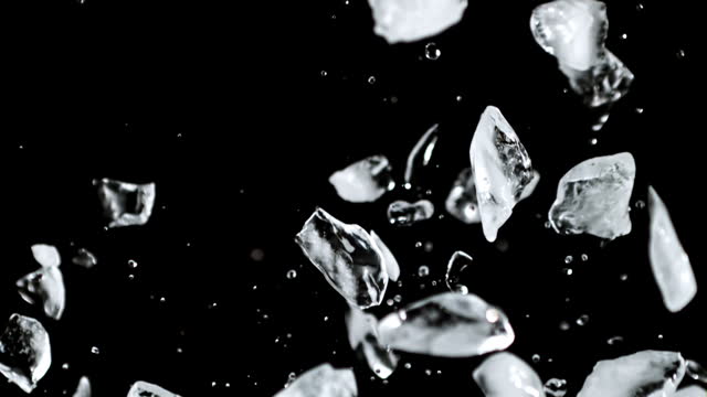 Super slow motion pieces of ice rise up and fall down