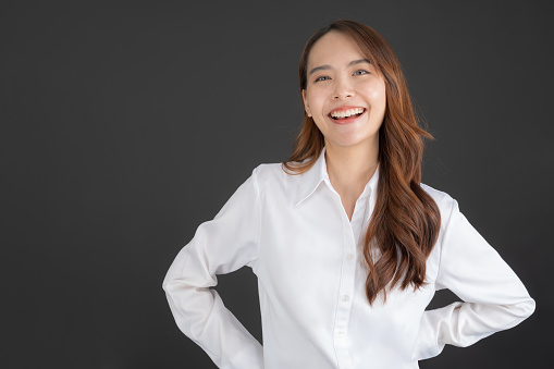 Business woman wearing white shirt Standing and doing various poses on a black background.