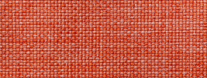 Texture of dark orange color background from woven textile material with wicker pattern, macro. Structure of vintage red fabric cloth, narrow backdrop.