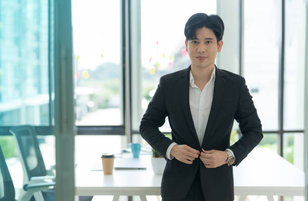 istock Smiling asian businessman standing in home office 2147683030