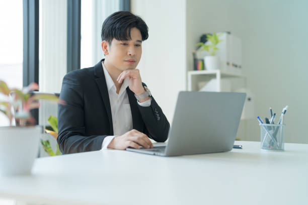 istock Attractive businessman working on laptop in workstation office. 2147683037