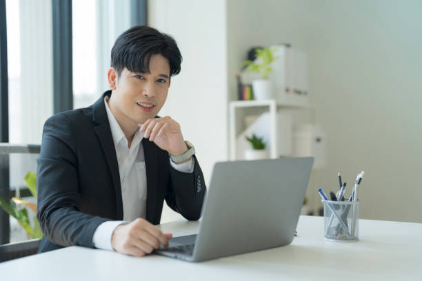 istock Attractive businessman working on laptop in workstation office. 2147683042