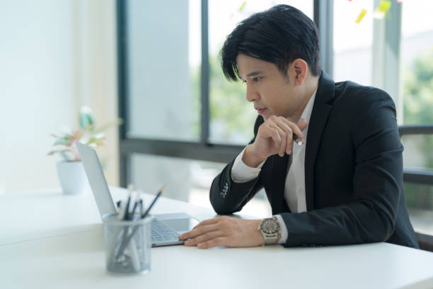 istock Attractive businessman working on laptop in workstation office. 2147683044