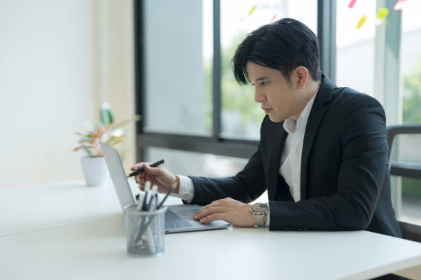 istock Attractive businessman working on laptop in workstation office. 2147683051