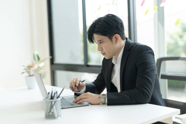 istock Young businessman opening a notebook View emails from customers sent. and write down the details. 2147683126