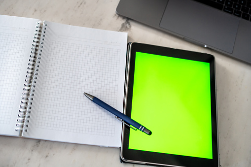 notebook pencil tablet of green screen are on table horizontal concept of choise still