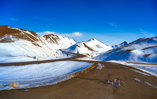 Snow-covered mountains and freshly cleared mountain roads in Iceland.