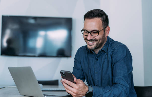 istock Businessman texting on cellphone in the office. 2147683443