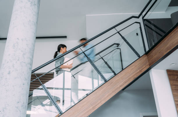 Businesspeople walking on busy office staircase.
