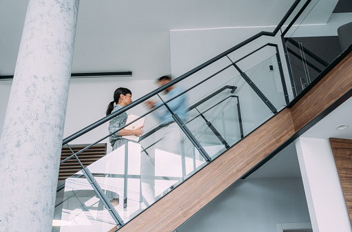 Shot of two business persons in a blurred motion on stairs in the office.