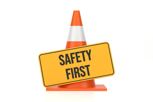 Traffic Cone And Safety First Sign On White Background