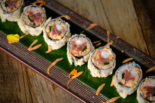 istock Delicious fried sushi with cream on tray over wooden table 2147684571