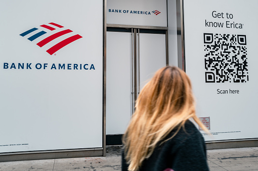 New York, United States of America - February 23, 2024: Image showing people passing by the Bank of America branch facade in Manhattan. Bank of America is a prominent financial institution in Manhattan, New York City, with multiple strategically located branches catering to diverse customer needs. These branches offer modern facilities and experienced staff to assist with banking inquiries, including ATMs for convenient transactions. In addition to traditional services like checking and savings accounts, loans, and credit cards, Bank of America in Manhattan also provides specialized services such as wealth management and investment advice, offering comprehensive financial solutions tailored to individual needs.