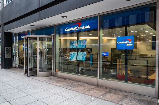 New York, United States of America - February 23, 2024: Wide image of a Capital One Bank Branch, in the heart of Manhattan, this bank branch stands as a pillar of financial services in the bustling city. With its sleek, modern design and inviting atmosphere, the branch offers a wide range of banking solutions tailored to meet the diverse needs of its customers. From everyday banking services like checking and savings accounts to specialized offerings such as investment advice and mortgage assistance, Capital One provides comprehensive support for individuals and businesses alike. Staffed by knowledgeable professionals committed to delivering exceptional customer service, the branch serves as a trusted partner for navigating the intricacies of finance in the vibrant urban landscape of Manhattan.