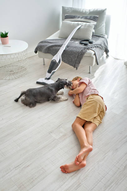 istock Dog licking face of tired boy 2147686736