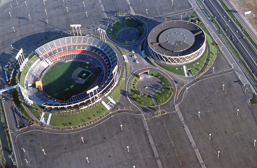 Oakland, California, USA - July 1978: Aerial view of Oakland-Alameda County Coliseum Complex including the Oakland Coliseum and Oakland Arena. The coliseum is used for both football and baseball. The arena is used for basketball. Special events are held in both venues.