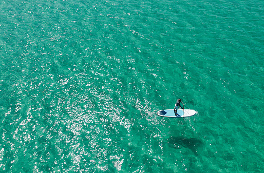 Drone shots of paddle boarder riding a SUP on the sea