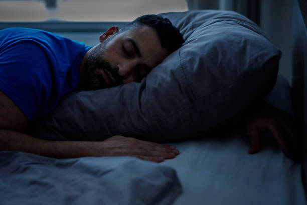 istock Sleeping young arab sleeping night, resting peacefully in a comfortable bed with gray linens with closed eyes, free space. 2147688748
