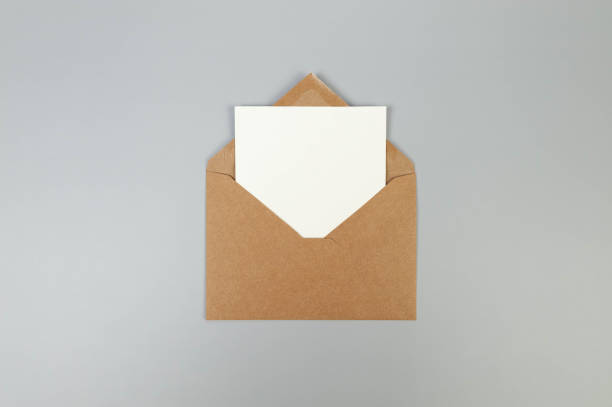 istock Top view of kraft brown envelope, white card on grey background. 2147688889