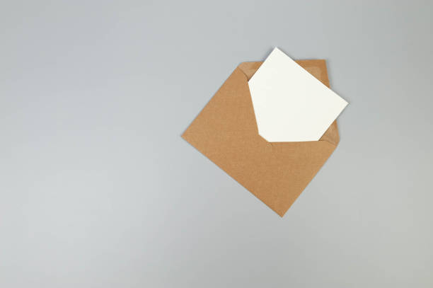 istock Top view of kraft brown envelope, white card on grey background. 2147688904