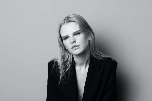 istock Young expressive beautiful blonde professional model posing isolated in studio dressing in black jacket looks at camera. Fashion Minimalistic concept 2147689088