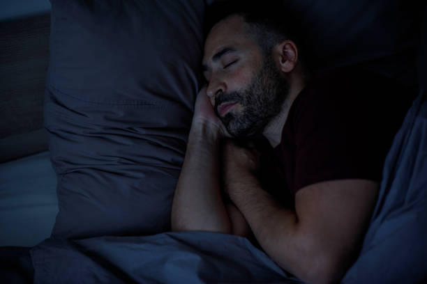 istock A calm young man with a beard sleeps in bed, on a soft pillow under a blanket in a bedroom interior. 2147689178