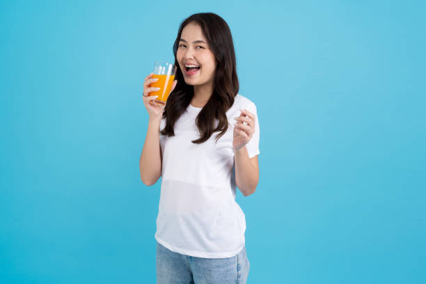 istock Beautiful woman drinking orange from a glass 2147689349