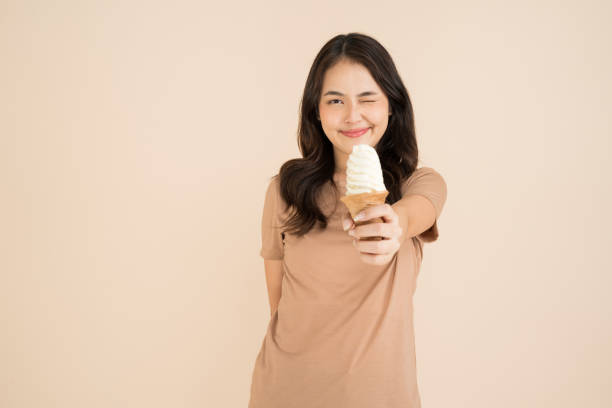 istock Happy young woman eating ice cream 2147689445