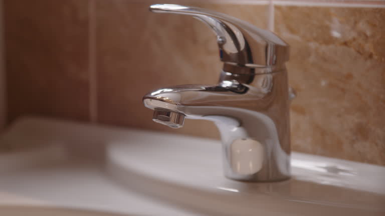 Close-up to faucet and sink, where water droplets delicately drip, underscoring faucet and sink importance of maintaining hygiene of surfaces to prevent spread of diseases faucet and sink.