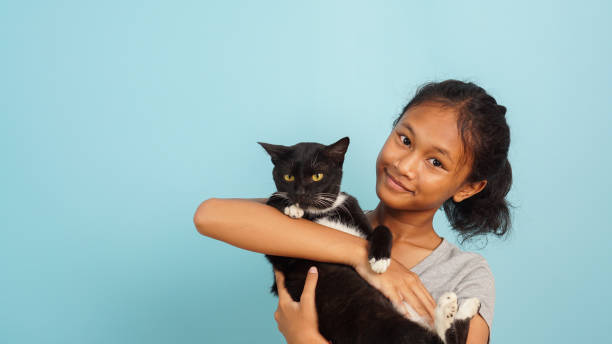 istock Young Asian girl smiling while hugging her black cat 2147689800