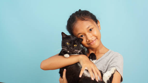 istock Young Asian girl smiling while hugging her black cat 2147689846