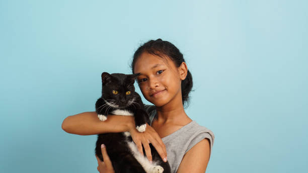 istock Young Asian girl smiling while hugging her black cat 2147689847