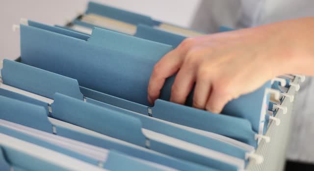 Woman manager secretary puts blue folder with documents into stick