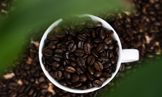 Natural coffee beans in a cup. Close up. Top view. Selective focus.