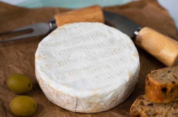 istock Camembert cheese, olives and sliced fresh baguette on the table. Close-up. Selective focus. 2147692666