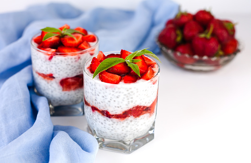 Tasty dessert with fresh strawberry, yogurt and chia seeds on white background. Healthy food concept. ?lose-up. Copy space.