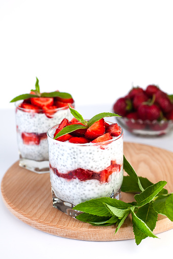 Tasty dessert with fresh strawberry, yogurt and chia seeds in glasses. Diet breakfast. lose-up.