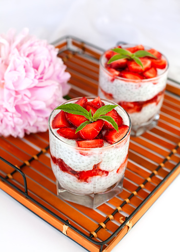 Healthy food concept. Healthy breakfast of fresh strawberry, yogurt and chia seeds on a wicker tray. lose-up.