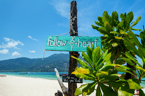 Blue wooden sign at the beach on the island,beach background