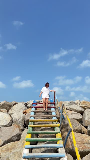 Woman Going Down a Wooden Staircase at Beach