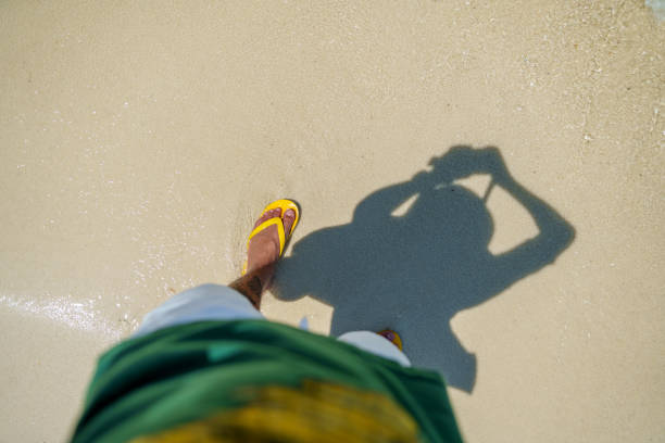 Feet and sandals on the sand at the beach,travel