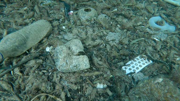 Close-up of a lot plastic debris at seafloor in a crevice between rocks, Slow motion