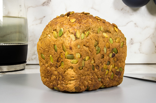 A loaf of bread with seeds on top of it. The bread is brown and has a nutty flavor